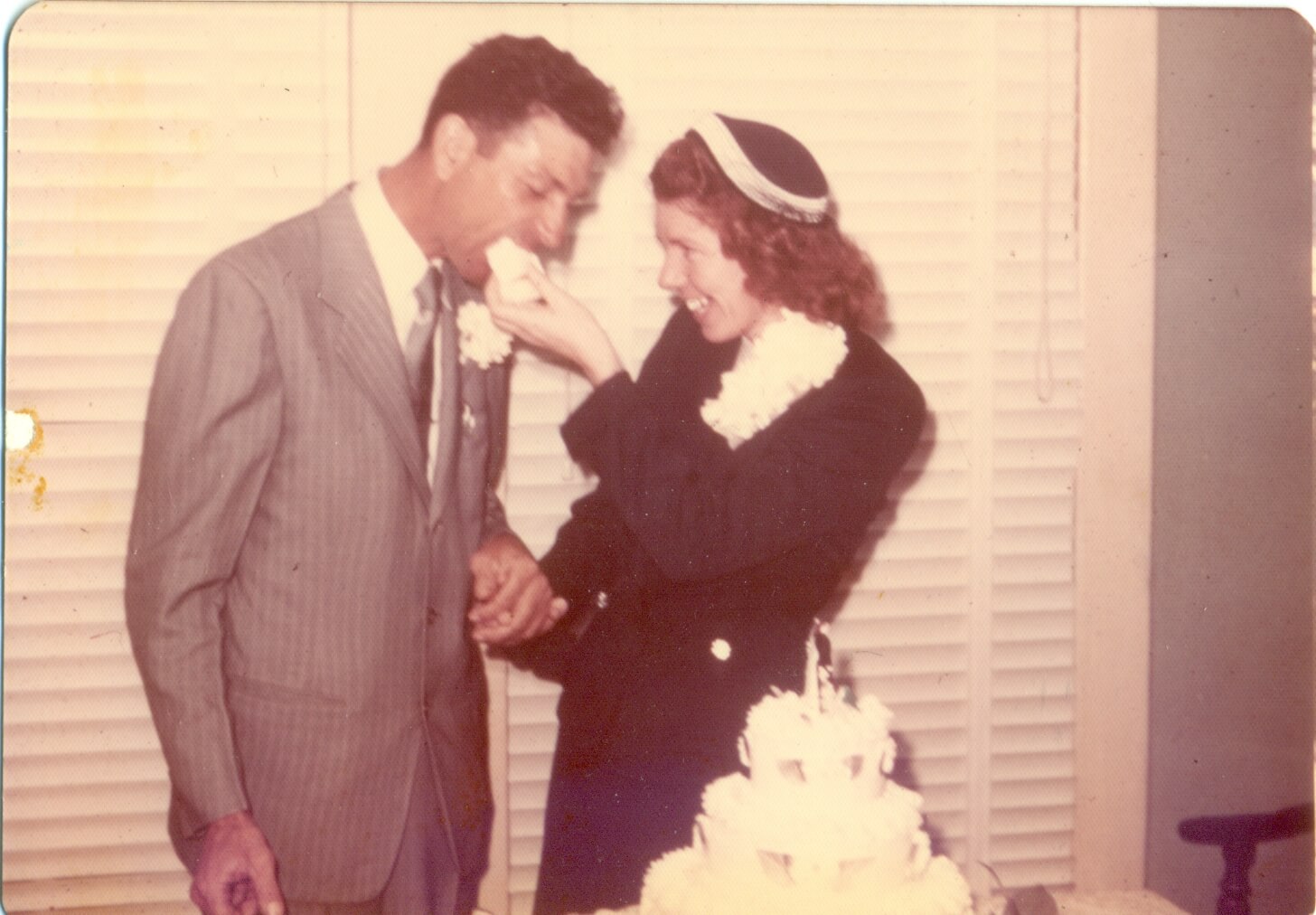 Basil and Juanita feeding cake to each other