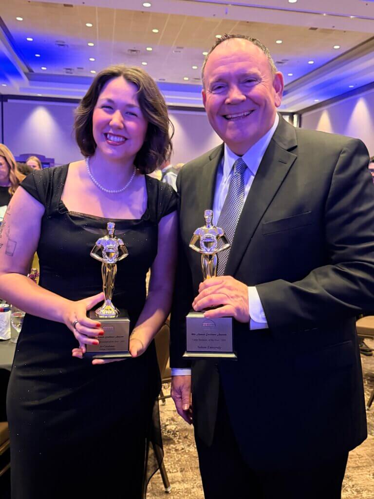 Jo Cardenas posing with President Bridges with awards.