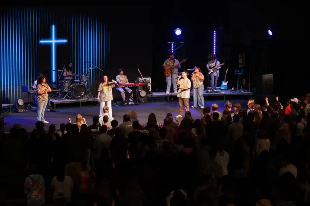 students in chapel worshiping